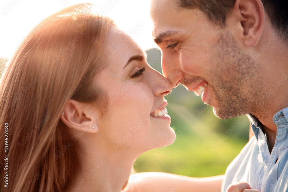 Cute young couple in love posing outdoors on sunny day Cute young couple in love posing outdoors on sunny day