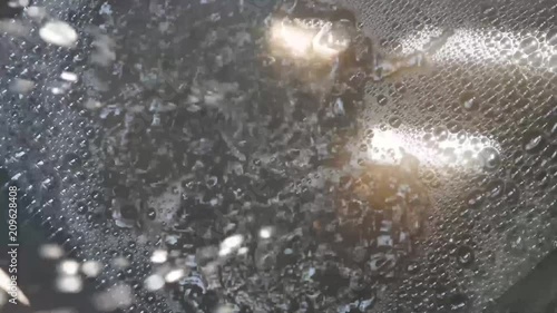 Rain water flowing into a drain.Rainwater flows on the asphalt road and fall into the metal hatch with holes drain.Rainwater flows on the road and fall into the metal hatch with holes drain.