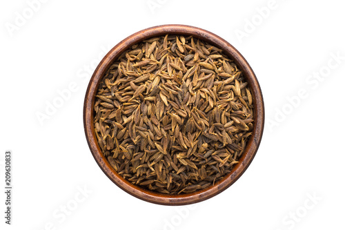 zira black spice in wooden bowl, isolated on white background. Seasoning top view
