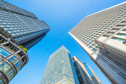 Asia Business concept for real estate and corporate construction - looking up view of panoramic modern city skyline with blue sky in tokyo, japan