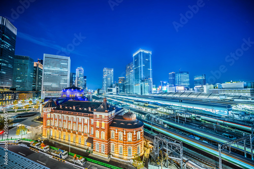 Asia Business concept for real estate and corporate construction - panoramic urban city skyline aerial view and tokyo station with train railroad under twilight sky and neon night in tokyo, Japan