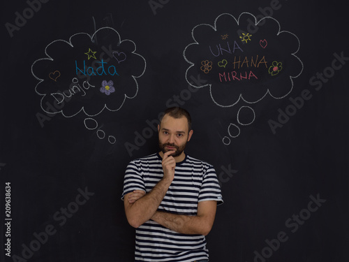 young future father thinking in front of black chalkboard