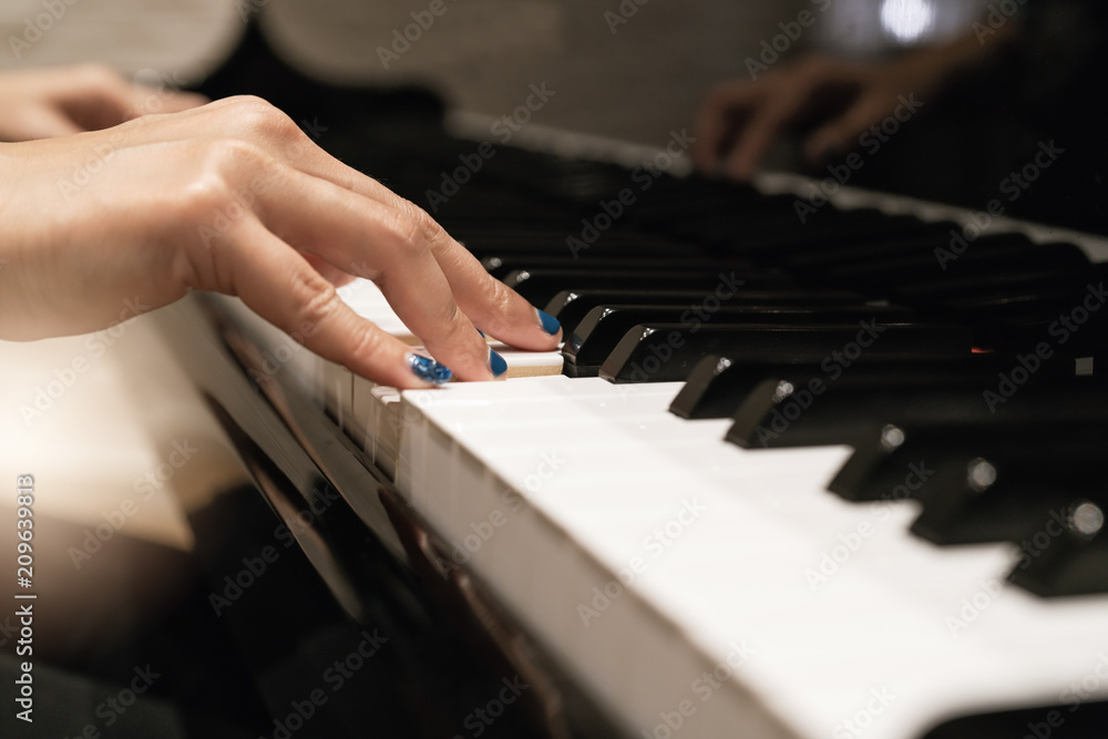 Fototapeta premium women hand on classic Piano keyboard closeup