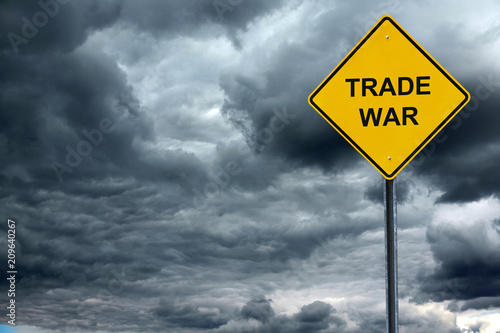 road warning sign with text trade war in front of storm cloud photo