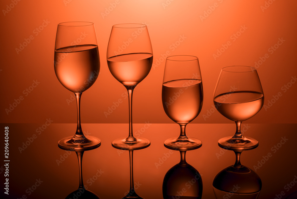 Glasses with water on a red background.