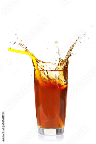 Splashes from a glass with refreshing tea and lemon on a white isolated background.