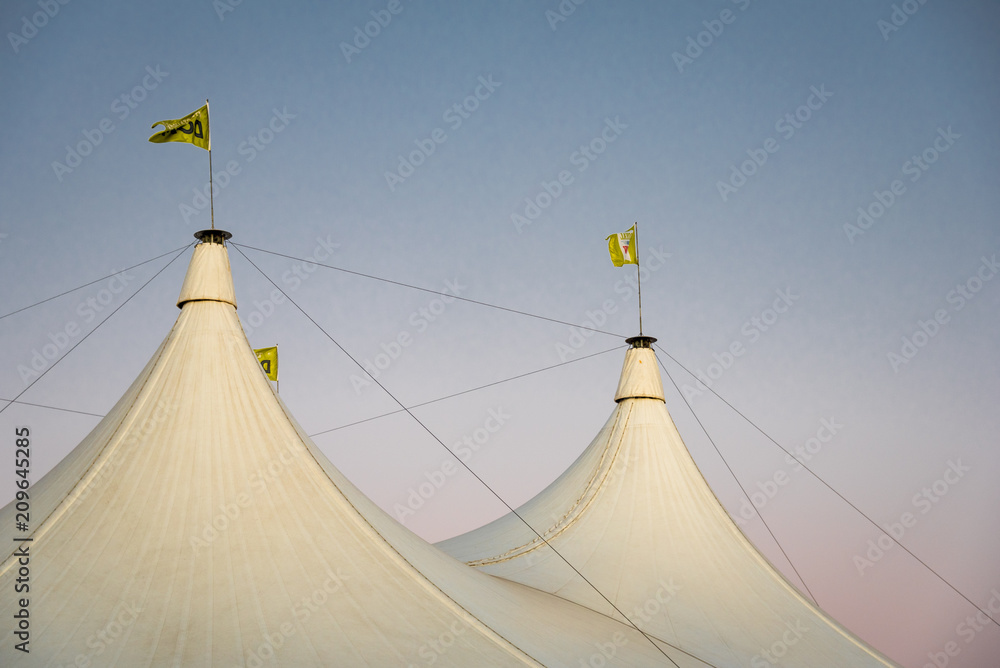 Carnival tent tops against a pink dusk sky