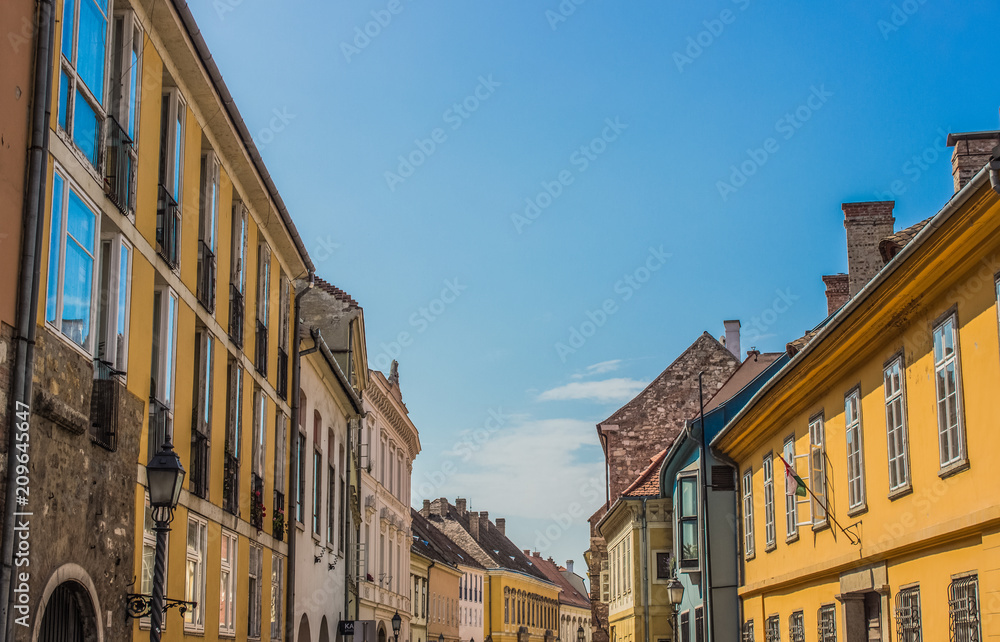 colorful cozy and small old city street in summer bright day with blue sky background