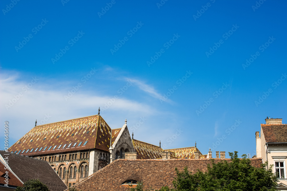 colorful facade roofs of houses in summer day bright old city street on blue sky background