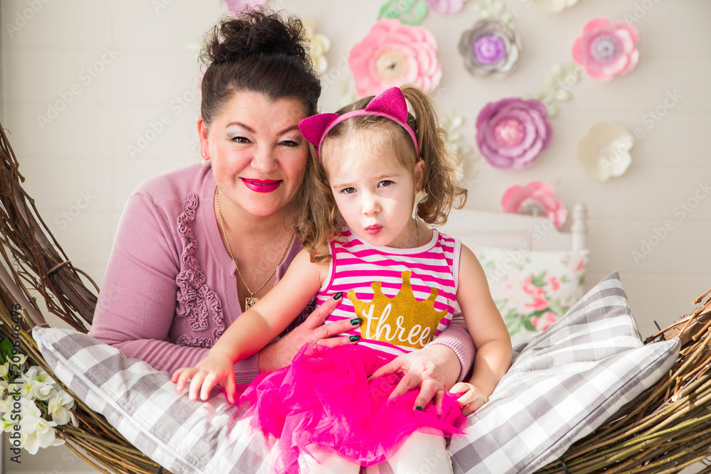grandmother and granddaughter look at the camera and smile grandmother and granddaughter look at the camera and smile