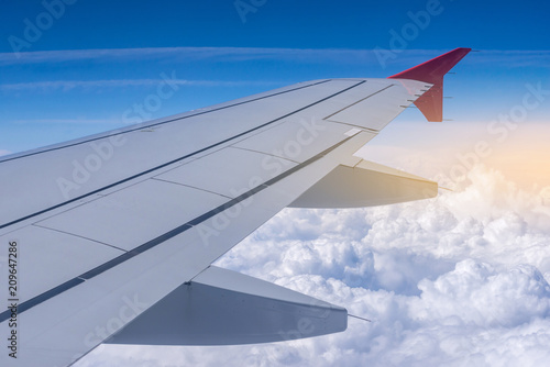 Wing of airplane in flight on a background of clouds. Concept of travel and flights to new countries