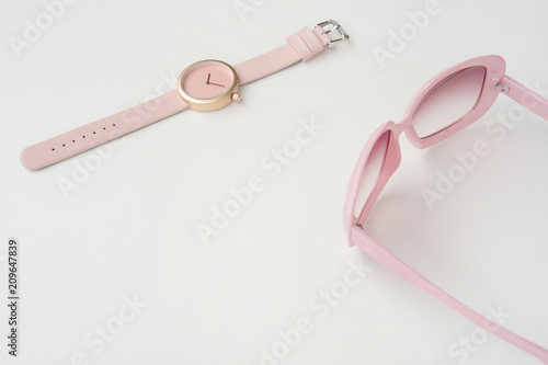 Set of multicolored wristwatches with fashionable sunglasses for background