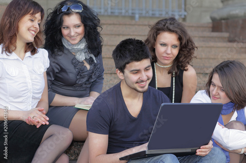 group of students communicating via the Internet using laptop
