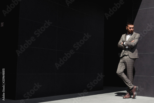 Smartly dressed businessman, Modern businessman. Confident young man in full suit standing outdoors with building in the background © Gennady Danilkin