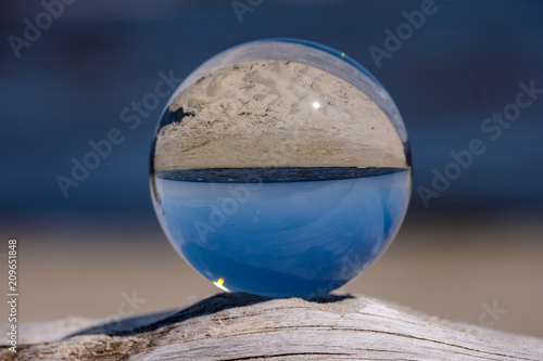 chrystal ball on a dry wood on the beach