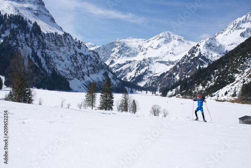 Skilangläufer vor Alpenbergen im Winter beim Skifahren14