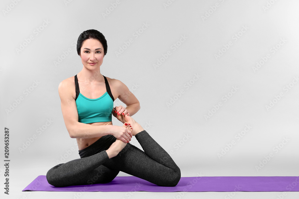 Fototapeta premium Beautiful woman practicing yoga on white background