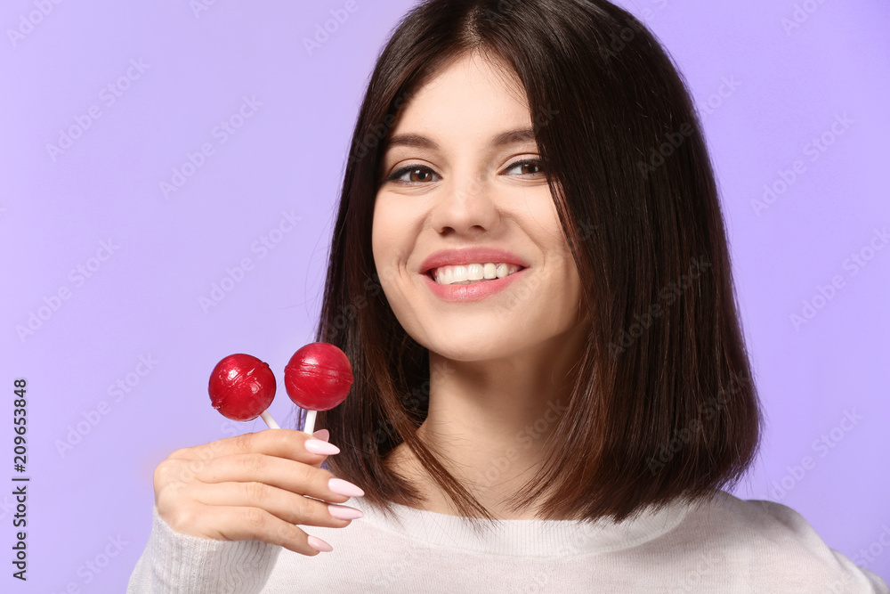 Beautiful young woman with lollipops on color background Beautiful young woman with lollipops on color background