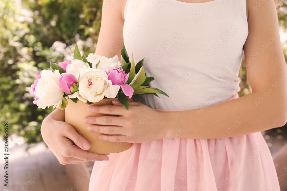 Woman holding box with beautiful peony flowers outdoors, closeup