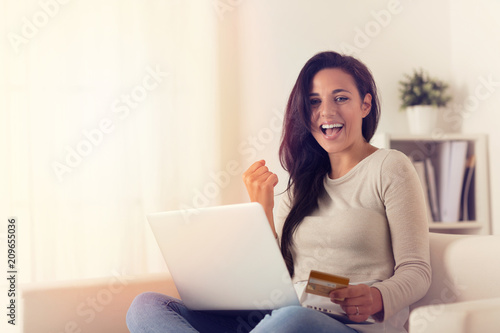 Joyful woman using laptop and buying online with credit card © guerrieroale