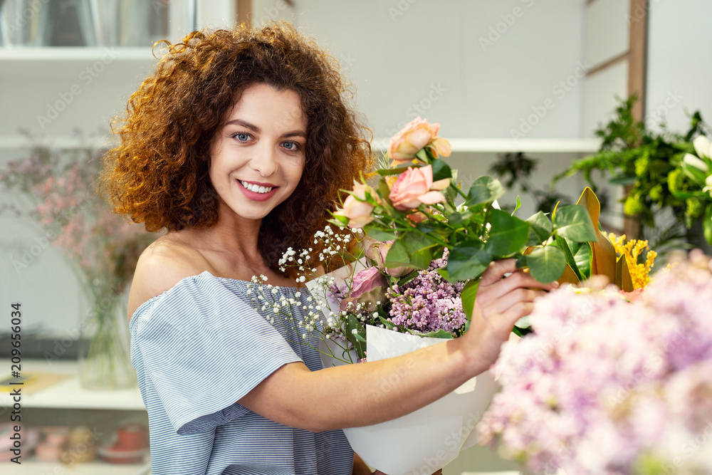 My passion. Attractive charming woman standing near flowers while enjoying them My passion. Attractive charming woman standing near flowers while enjoying them
