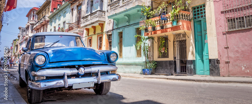 Vintage classic american car in a colorful street of Havana, Cuba. Panoramic travel photography.