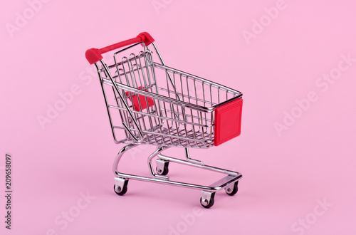 Empty shopping cart on pink background
