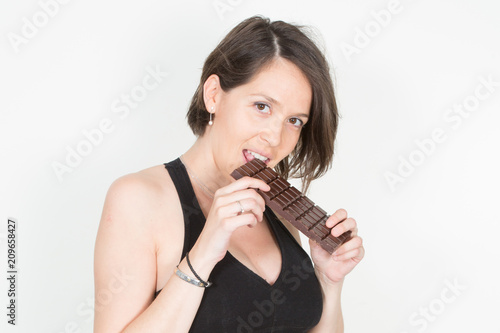 young beautiful girl holding a chocolate bar to enjoy the taste and dieting, healthy eating and organic foods, feeling temptation