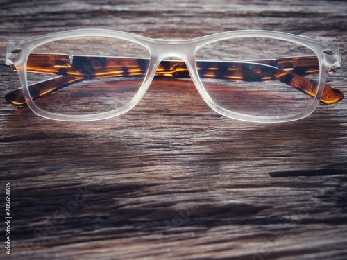 Glasses on the old wood table. And space for text or symbols in vintage tones with long-standing objects or items in memory.