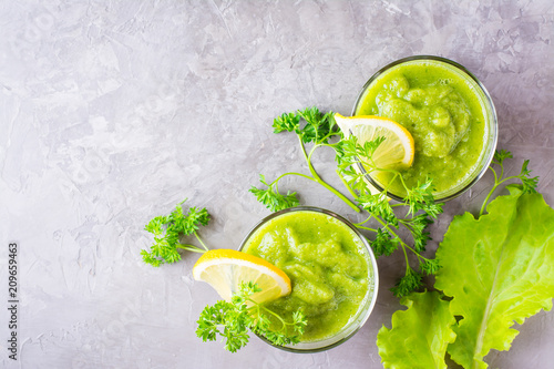 Refreshing smoothies from cucumber, green apple, fresh herbs and lemon juice in transparent glasses on the table. The concept of a healthy diet. Vegetarian menu. Top view
