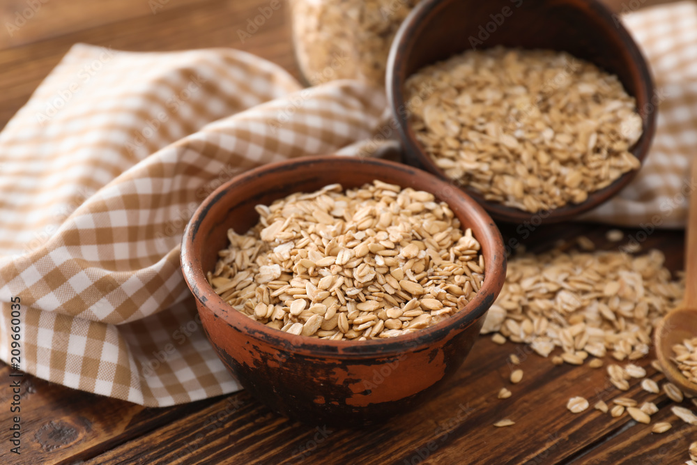 Bowl with raw oatmeal on wooden background Bowl with raw oatmeal on wooden background