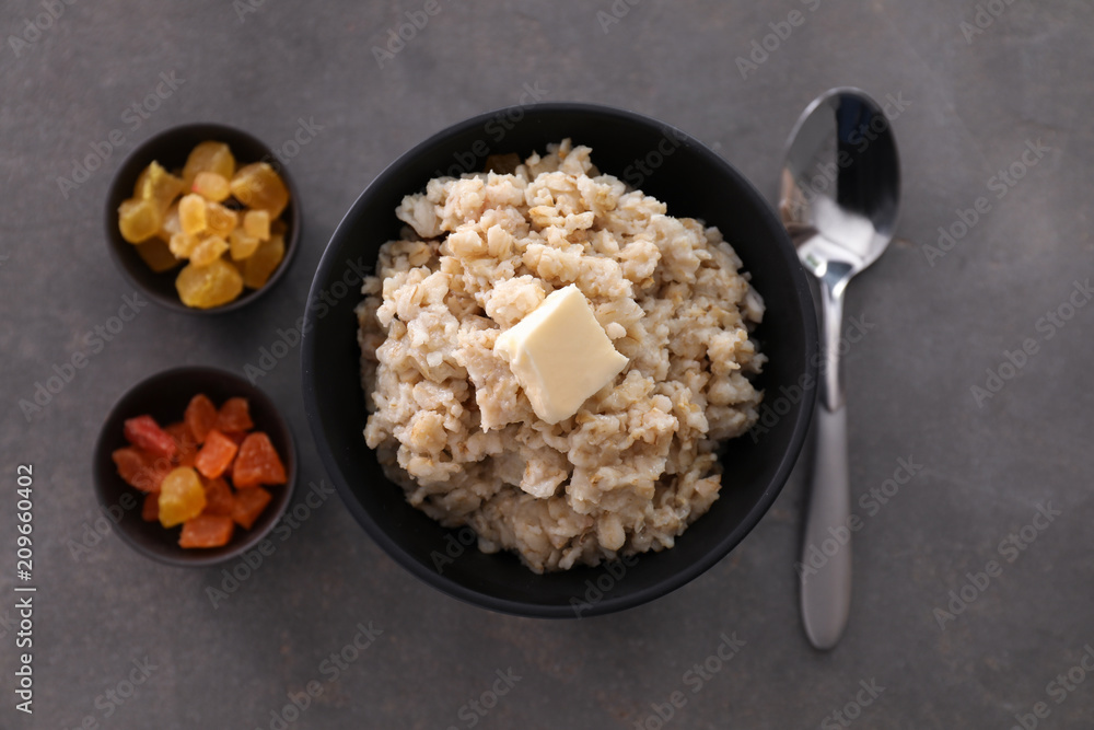 Tasty oatmeal and candied fruits on grey background Tasty oatmeal and candied fruits on grey background