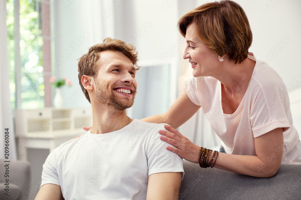 Fototapeta premium Happy motherhood. Joyful happy woman smiling while looking at her son