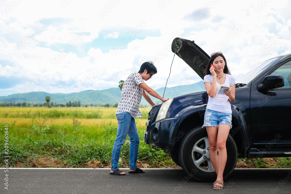 Naklejka premium Asia couple traveler have a problem about car.beautiful lady calling to insurance to help and fix her broken car stop near the road during her travel on vacation.