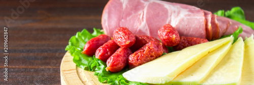 Assorted meat products including ham and sausages. cheese. Banner