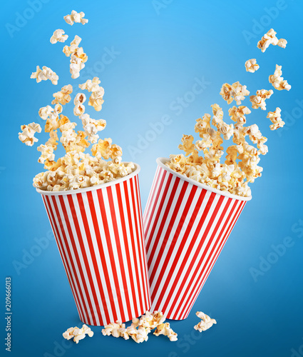 Falling popcorn in box. Popcorn in striped bucket.