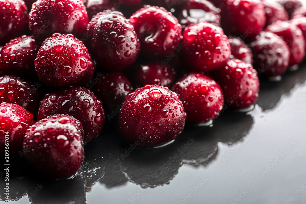 Tasty cherries with water drops on wet table, closeup Tasty cherries with water drops on wet table, closeup