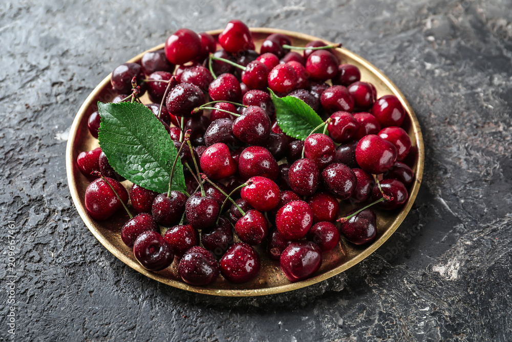 Plate with fresh ripe cherry on grunge background Plate with fresh ripe cherry on grunge background