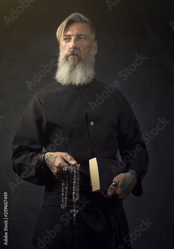 Portrait eines heiligen Priesters vor einem dunklen Hintergrund photo