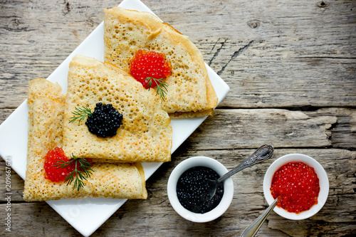 Thin yeast pancakes with red and black caviar, traditional dish of russian cuisine