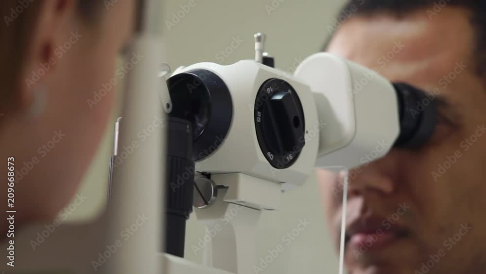 close up shot of the man's face, the person is working as an ophthalmologist in a private clinic and checks the eyesight for the patients, the doctor conducts biomicroscopy of the eyes close up shot of the man's face, the person is working as an ophthalmologist in a private clinic and checks the eyesight for the patients, the doctor conducts biomicroscopy of the eyes