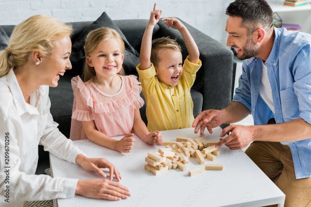 happy family playing with wooden blocks at home - obrazy, fototapety, plakaty 