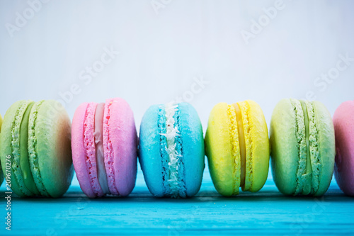 Delicious colorful macaron cakes on wooden background