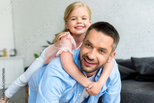 happy father and son having fun together and smiling at camera at home