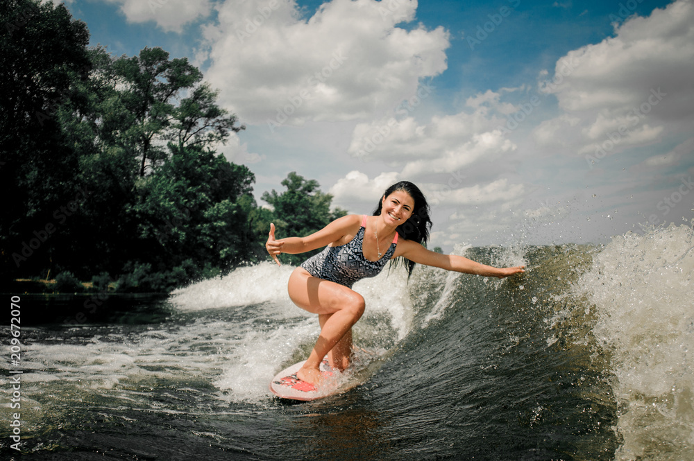 Young active woman riding on the wakeboard