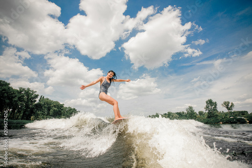 Young beatutiful woman riding on the wakeboard