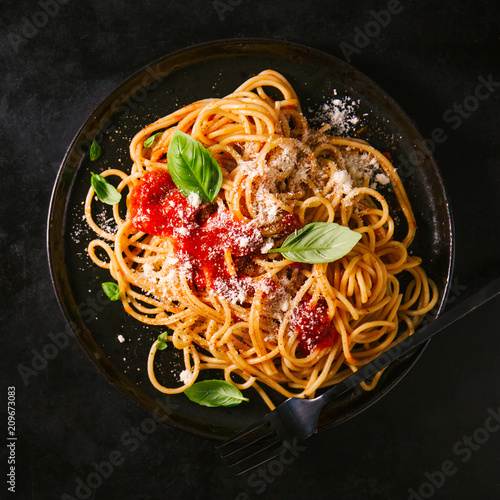 Fotografie Dark plate with italian spaghetti on dark