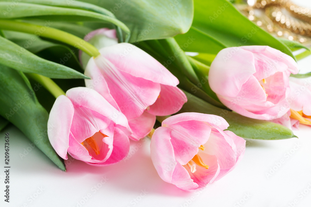 Pink fresh tulips with green leaves - spring female things, close up, bijouterie out of focus Pink fresh tulips with green leaves - spring female things, close up, bijouterie out of focus