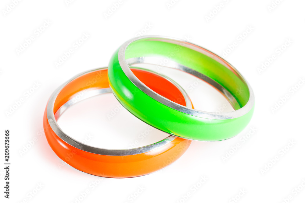 Two plastic stylish women bracelets - green and orange isolated on white Two plastic stylish women bracelets - green and orange isolated on white