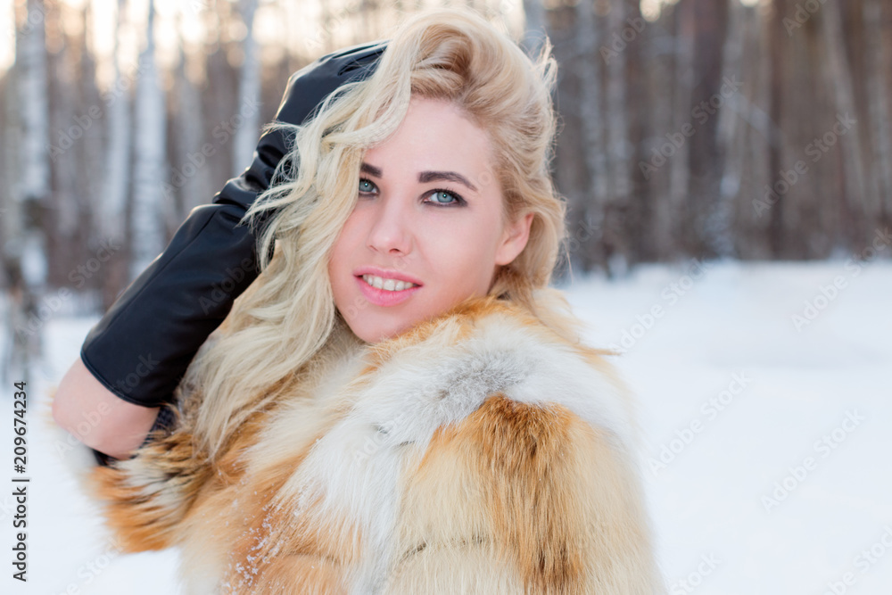 Pretty young woman in fur coat poses outdoor at winter day in forest Pretty young woman in fur coat poses outdoor at winter day in forest